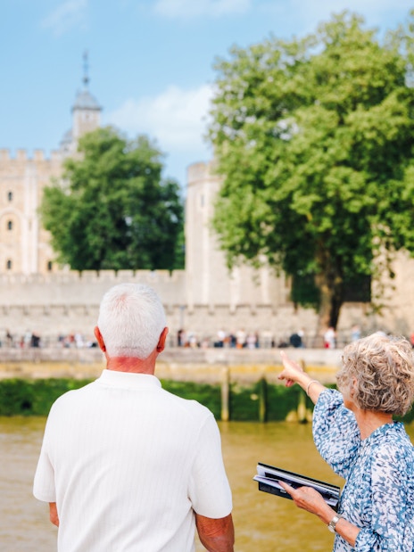 Guests viewing the Tower of London from a cruise boat on the River Thames.