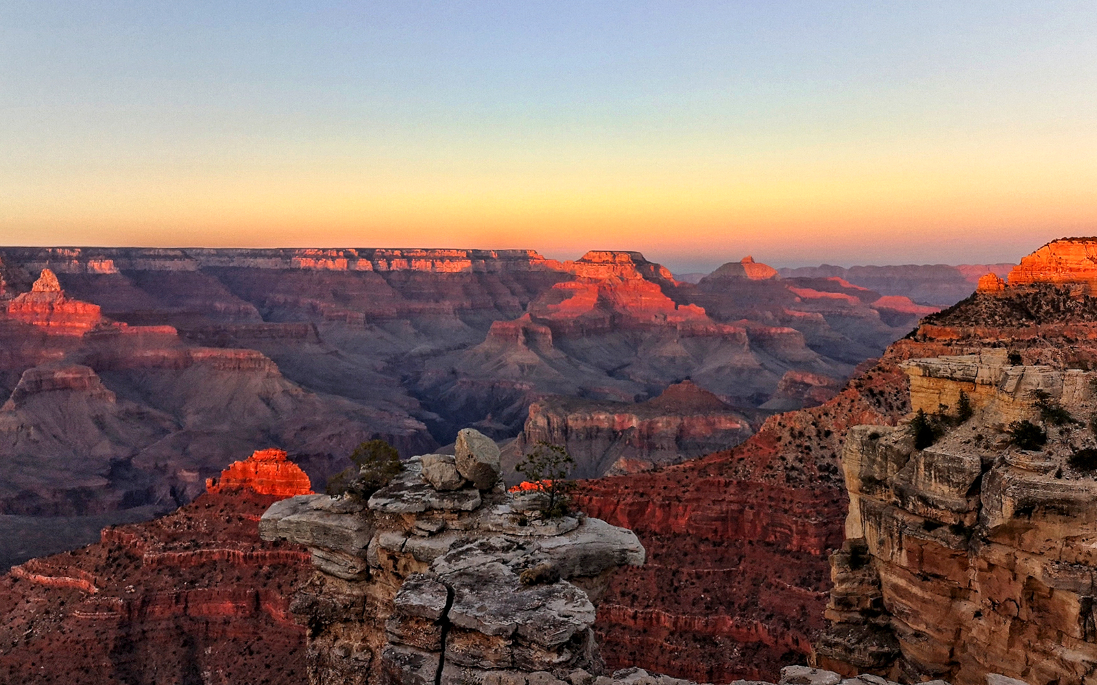 Grand Canyon at sunset with layered rock formations and vibrant colors.
