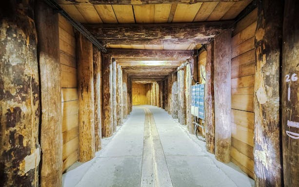 Wieliczka Salt Mine wooden corridor with support beams and electrical panels.