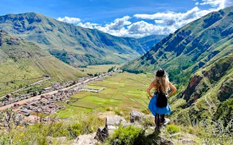 Traveler overlooking Sacred Valley landscape on guided tour from Cusco, Peru.