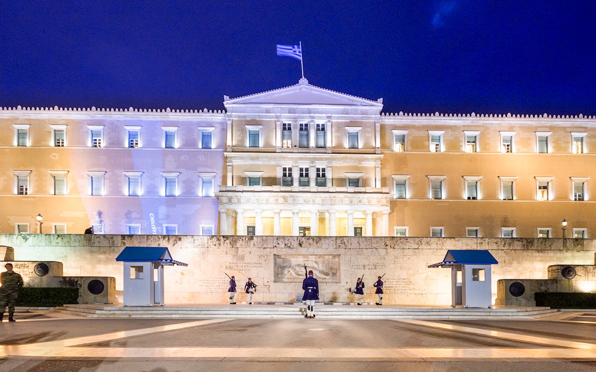 Greek Parliament building at Syntagma Square, Athens, with ceremonial guards.