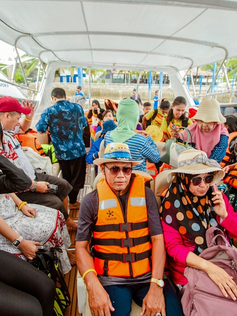 Tourists on a speedboat wearing life jackets during Surin Islands tour in Thailand.