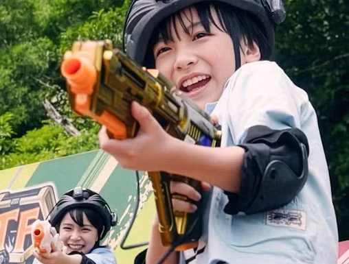 Children playing with toy guns at Junglia Okinawa theme park.