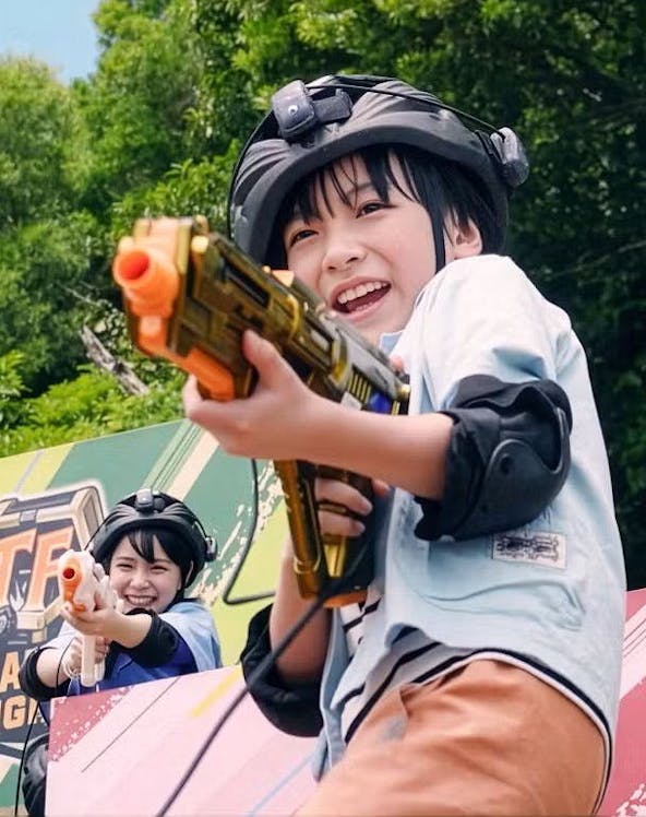 Children playing with toy guns at Junglia Okinawa theme park.