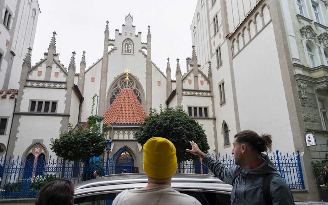 Tour guide showing guests the historic Jewish Quarter in Prague.
