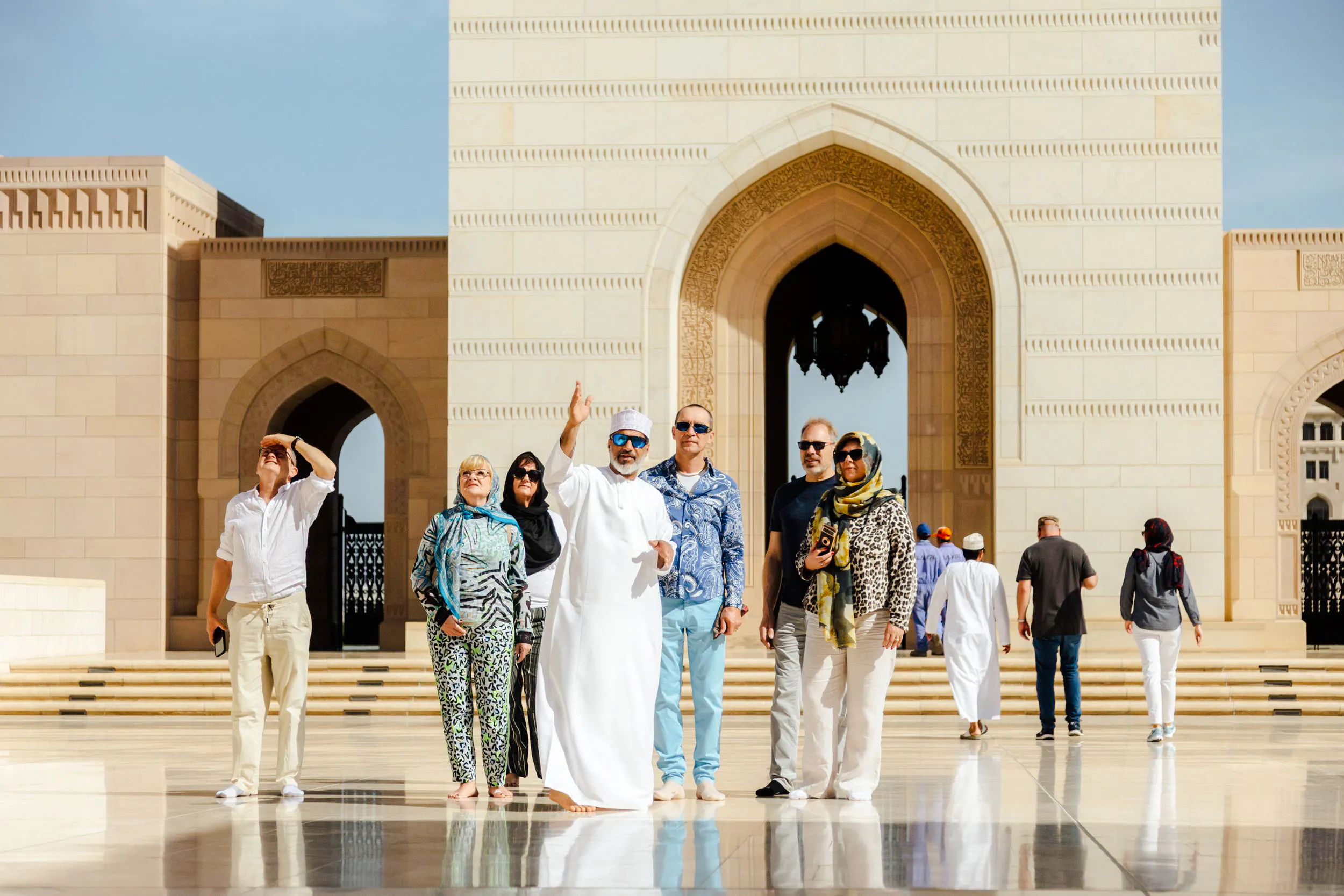 Tour group exploring Sultan Qaboos Grand Mosque in Muscat.