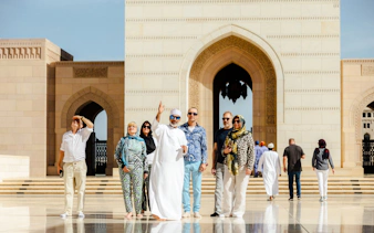 Tour group exploring Sultan Qaboos Grand Mosque in Muscat.