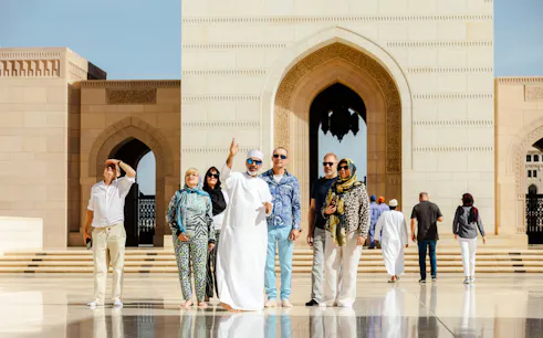 Tour group exploring Sultan Qaboos Grand Mosque in Muscat.