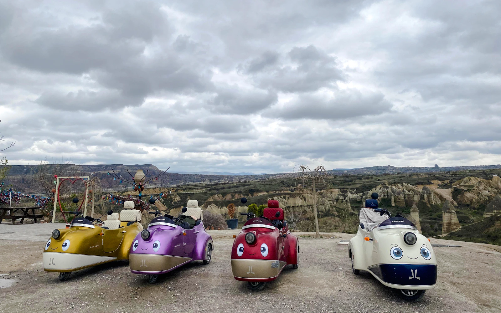 Vintage trike bikes parked with Cappadocia's rocky landscape in the background.
