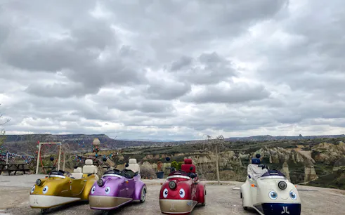 Vintage trike bikes parked with Cappadocia's rocky landscape in the background.