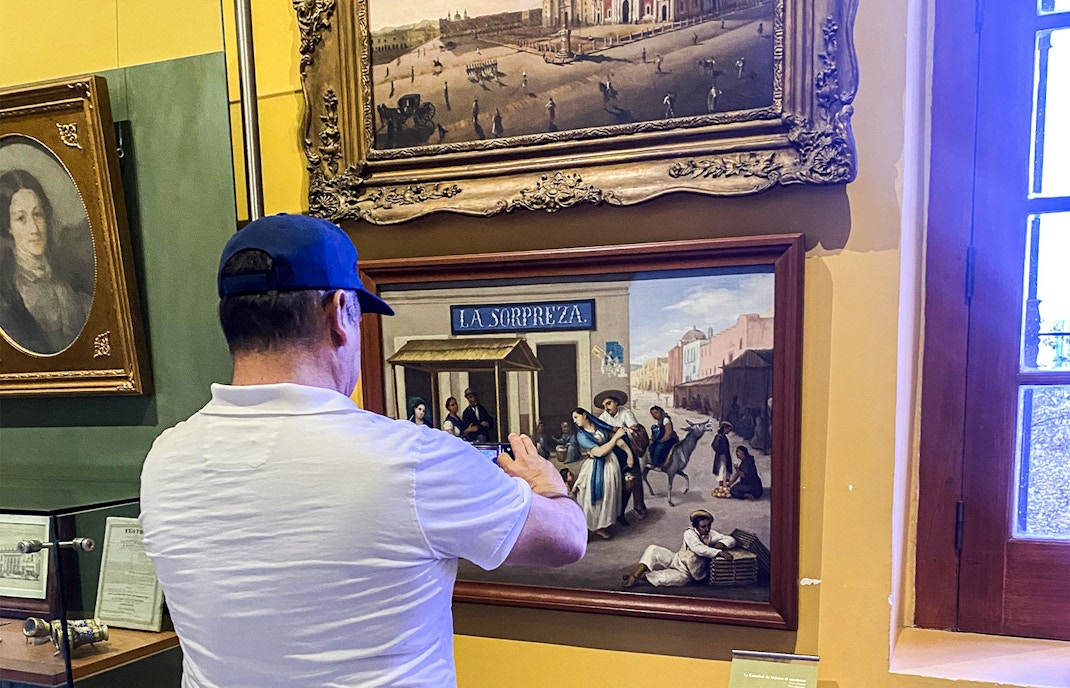 Chapultepec Castle in Mexico City with tourists exploring the historic architecture and lush surrounding gardens.
