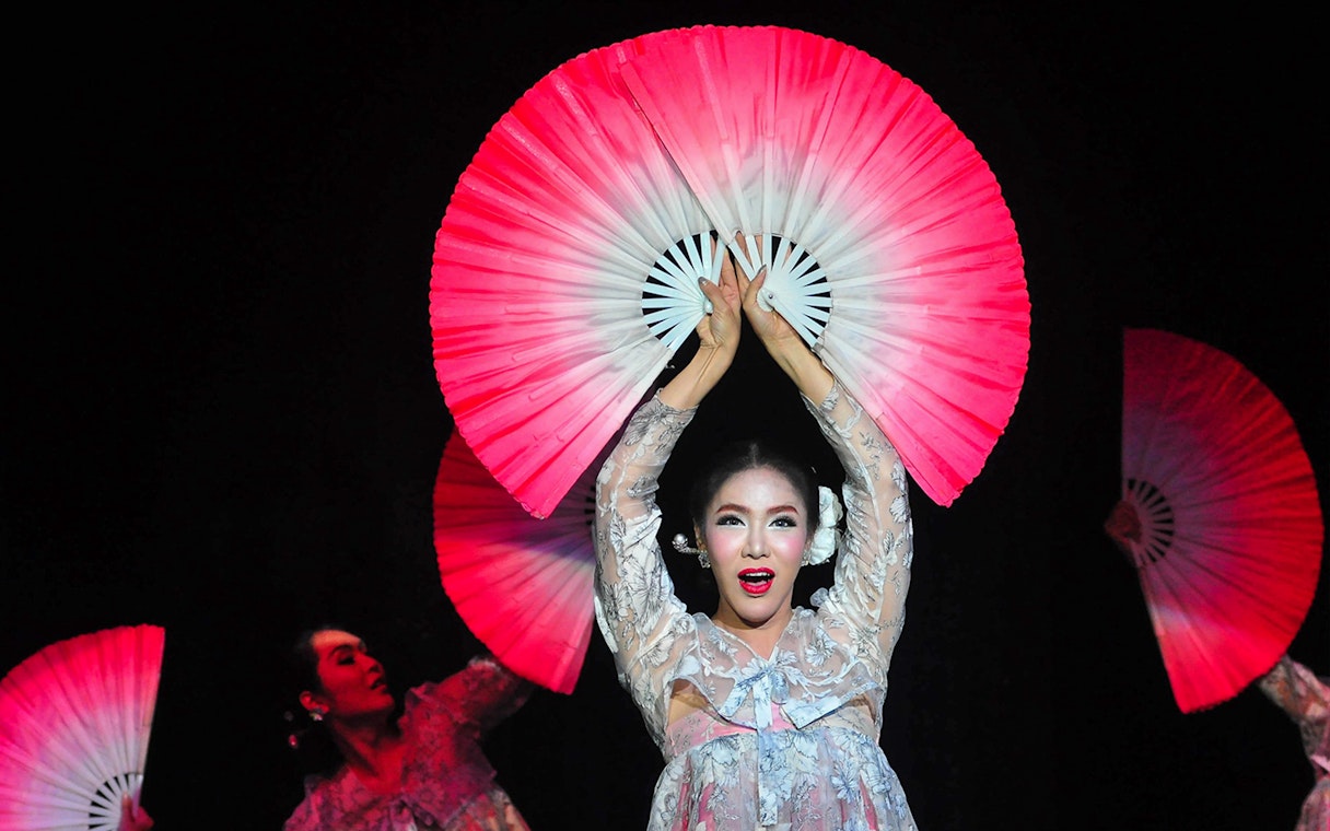 Performer with fans at Calypso Cabaret show in Bangkok.