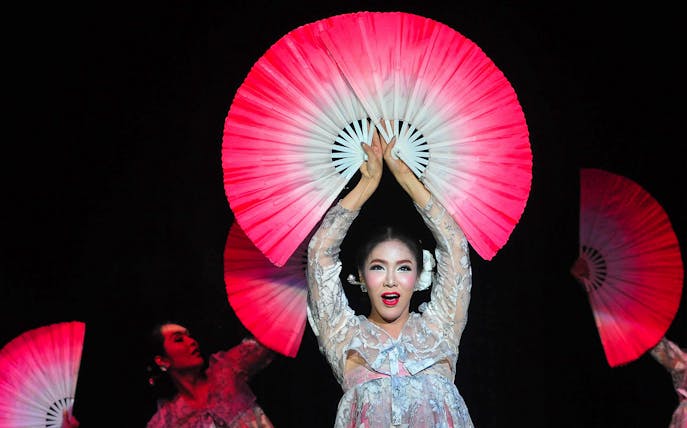 Performer with fans at Calypso Cabaret show in Bangkok.