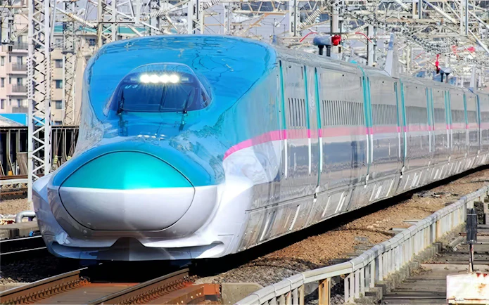 Japanese Shinkansen E5 Series bullet train on railway tracks.