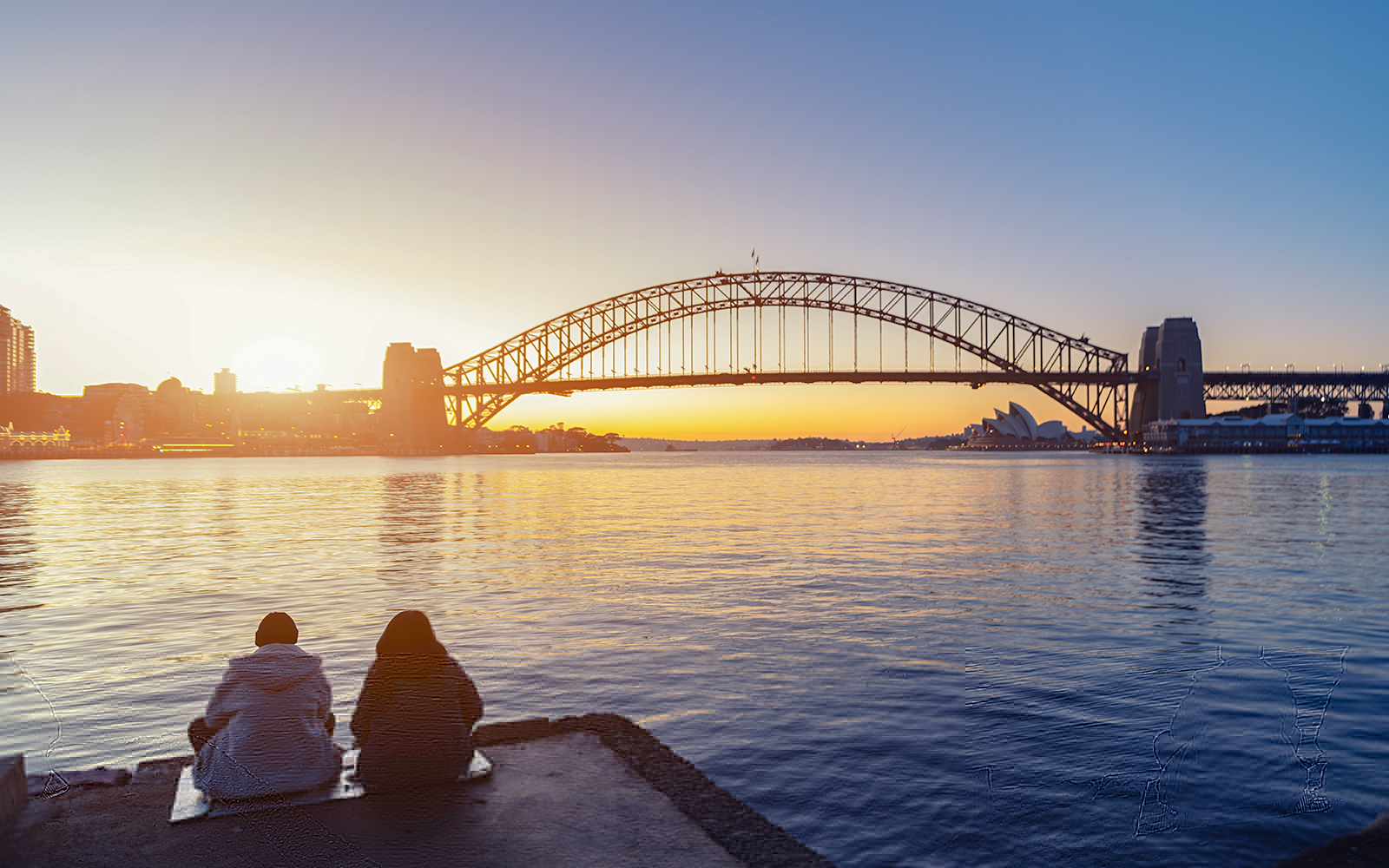 Romantic couple looks at Sydney skyline at dusk in Sydney New South Wales, Australia.