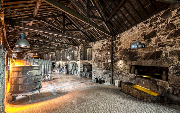 Burmester Cellars interior with wine barrels and stone walls, Porto, Portugal.