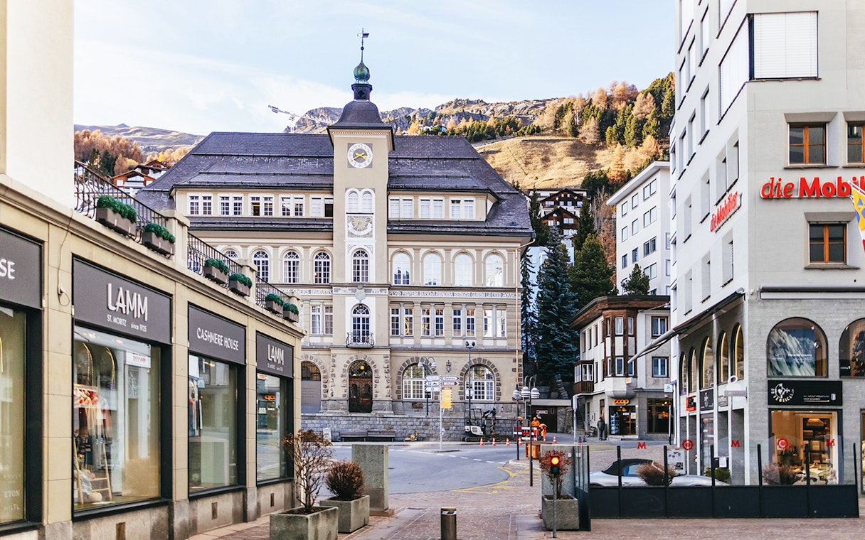 St. Moritz town center with historic building and mountain backdrop.