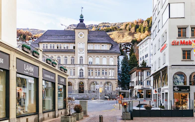 St. Moritz town center with historic building and mountain backdrop.