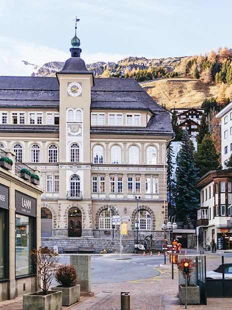 St. Moritz town center with historic building and mountain backdrop.