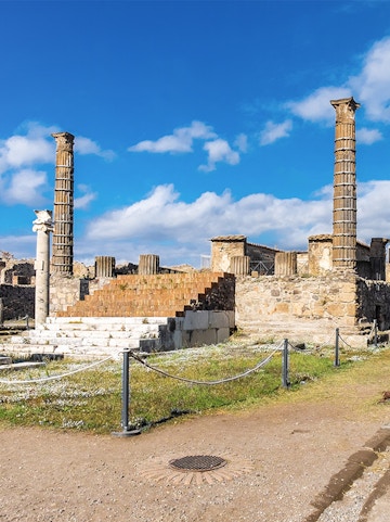 Ancient ruins with columns in Pompeii, Italy, viewed on a Naples to Pompeii tour.