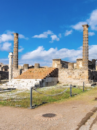 Ancient ruins with columns in Pompeii, Italy, viewed on a Naples to Pompeii tour.