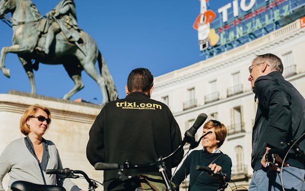 Group on bikes near equestrian statue in Madrid's Puerta del Sol.