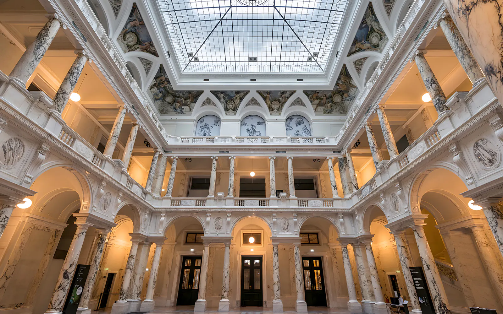 Weltmuseum Vienna interior with ornate columns and skylight.
