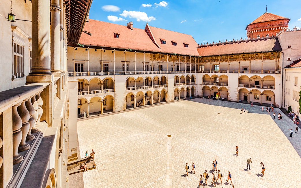 Wawel Castle courtyard with tourists in Krakow, Poland.