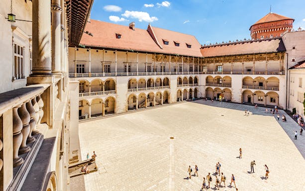 Wawel Castle courtyard with tourists in Krakow, Poland.