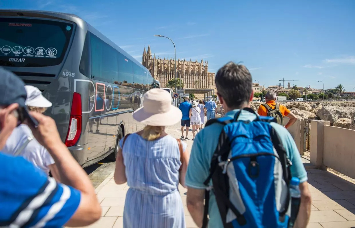 visitors getting out of bus and going towards Palma Cathedral