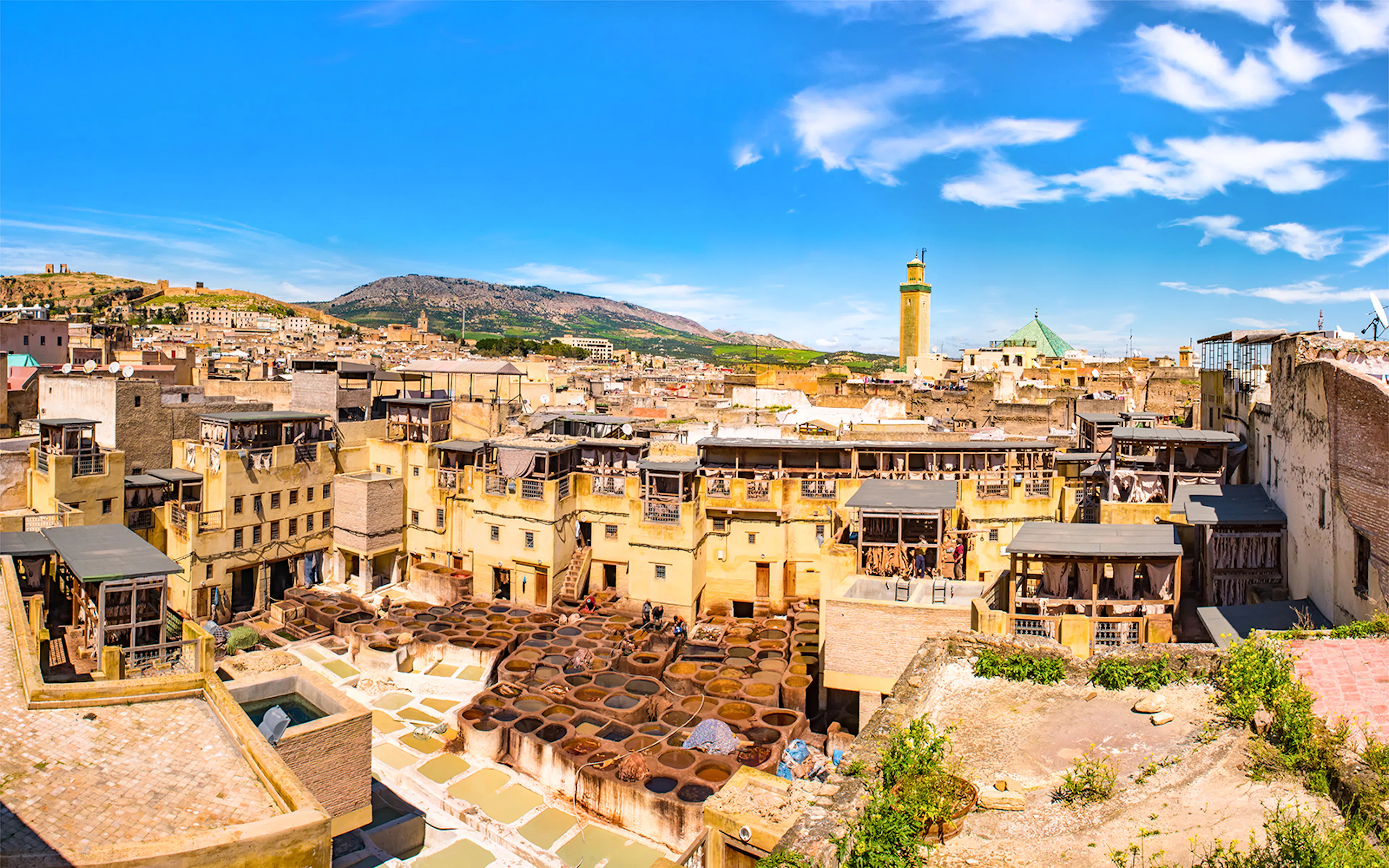 Chouara Tannery in Fez, Morocco, with traditional dyeing vats and cityscape.
