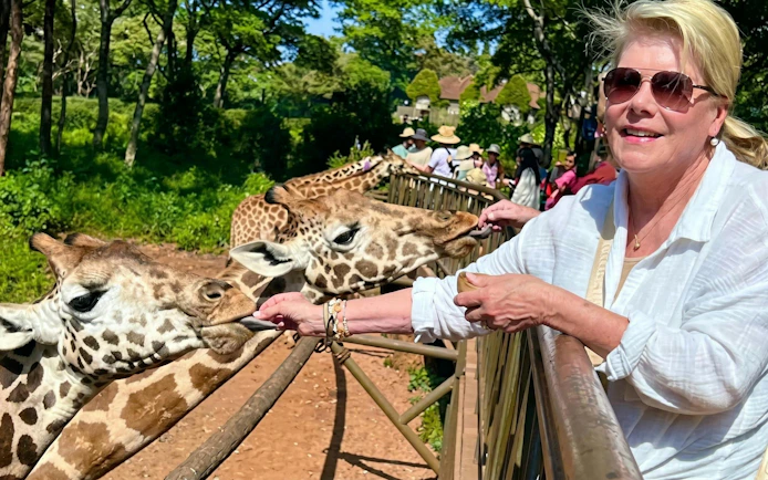 Woman feeding giraffe at Giraffe Centre, Nairobi.