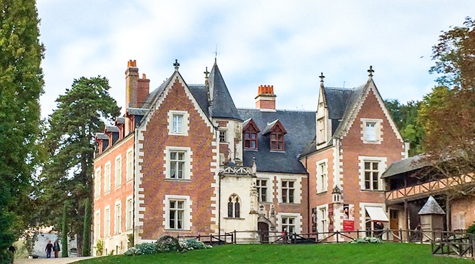 Château du Clos Lucé in Loire Valley with green lawn and trees.