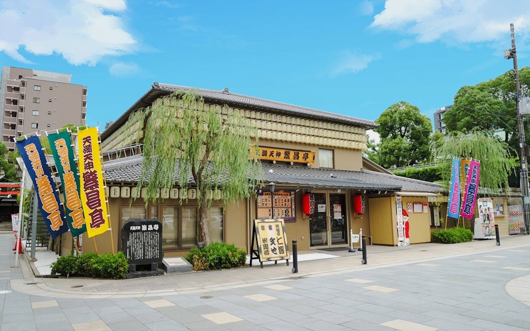Rakugo theater in Osaka, Japan with colorful banners and traditional architecture.