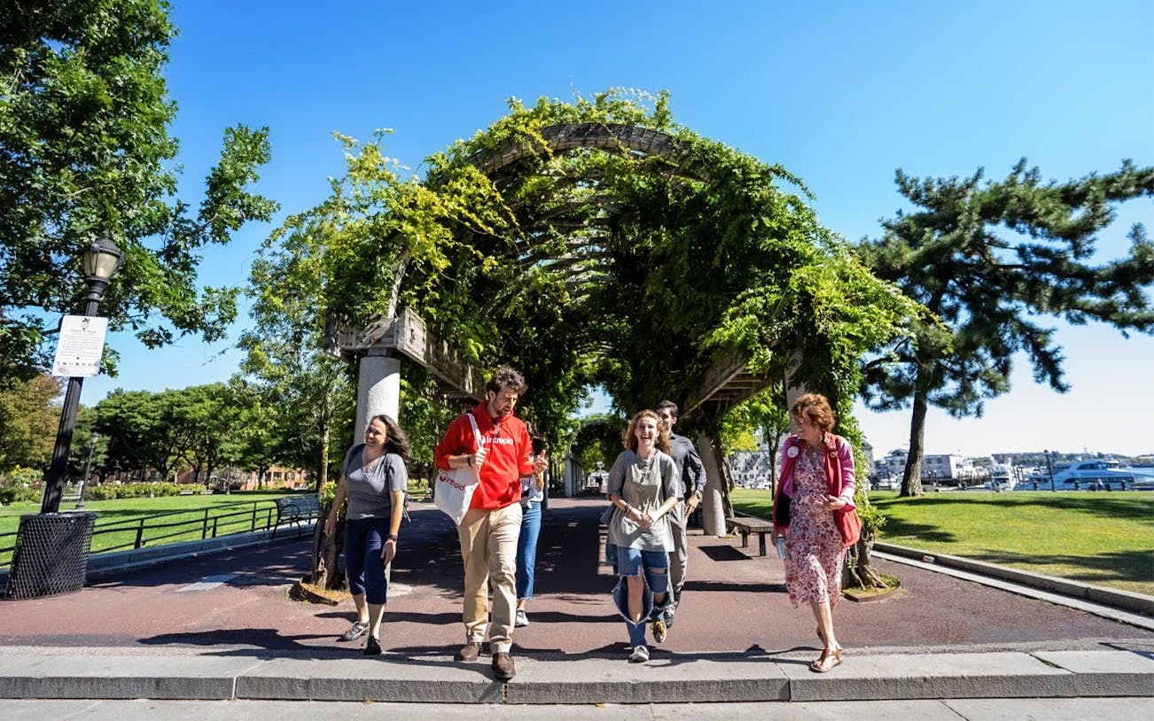 Tourists walking with guide under trellis on Boston History & Highlights Discovery Tour.