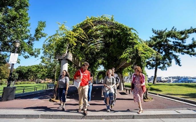 Tourists walking with guide under trellis on Boston History & Highlights Discovery Tour.