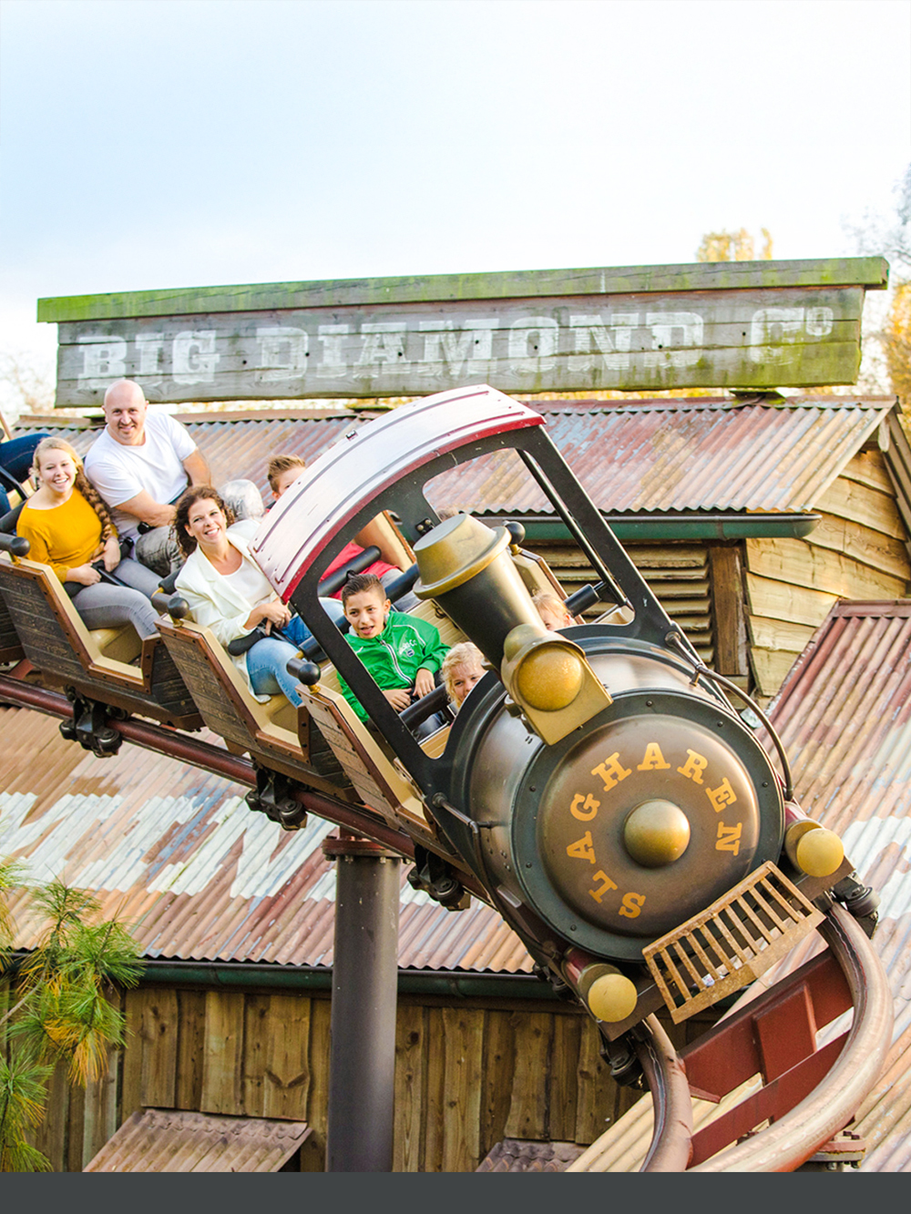 Roller coaster ride at Dubai theme park with children and adults enjoying the thrill.