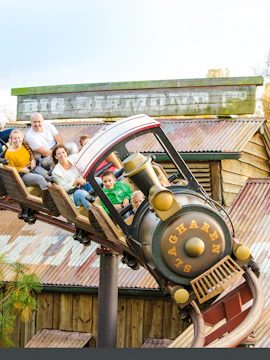 Roller coaster ride at Dubai theme park with children and adults enjoying the thrill.
