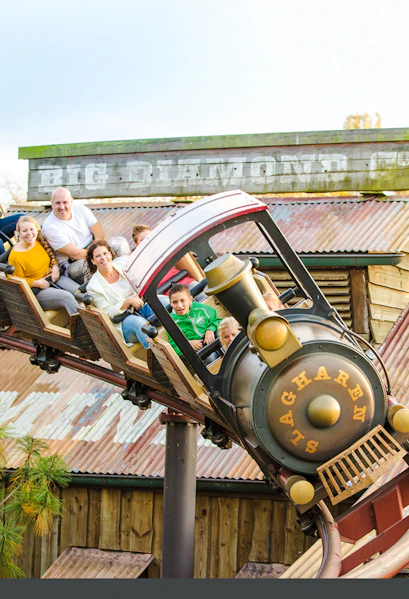 Roller coaster ride at Dubai theme park with children and adults enjoying the thrill.