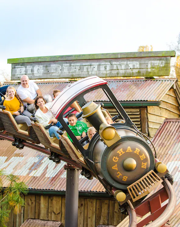Roller coaster ride at Dubai theme park with children and adults enjoying the thrill.