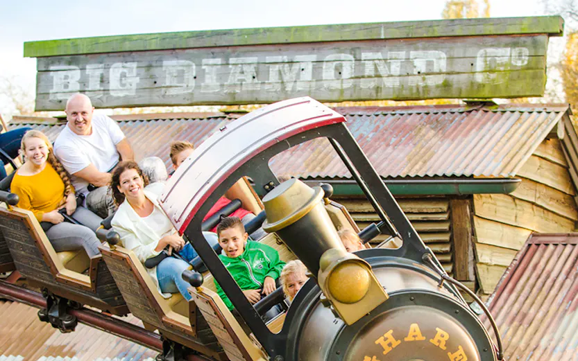 Roller coaster ride at Dubai theme park with children and adults enjoying the thrill.