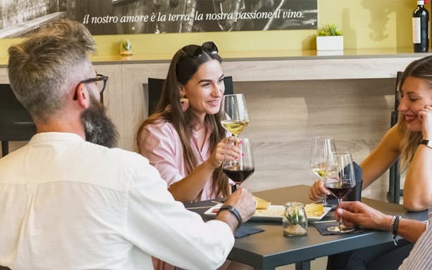 Wine tasting group enjoying glasses at a table in Alghero.