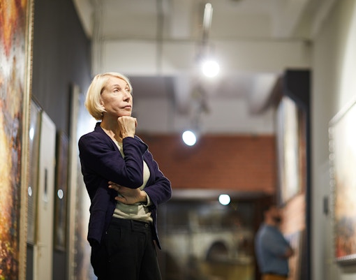 Person observing artwork in a gallery setting.