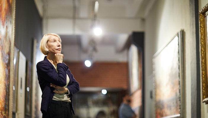 Person observing artwork in a gallery setting.