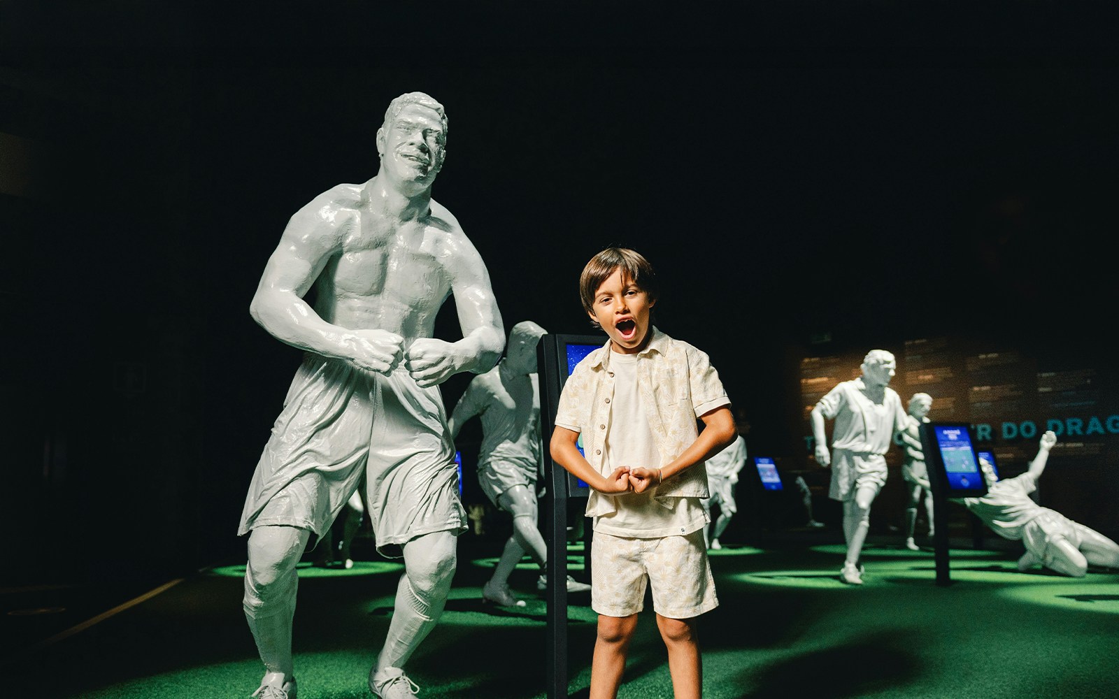 Visitors exploring FC Porto stadium museum with statues of legendary players.