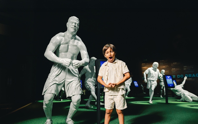 Visitors at FC Porto stadium museum with football legends statues.