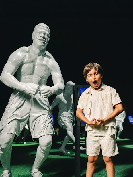 Visitors at FC Porto stadium museum with football legends statues.