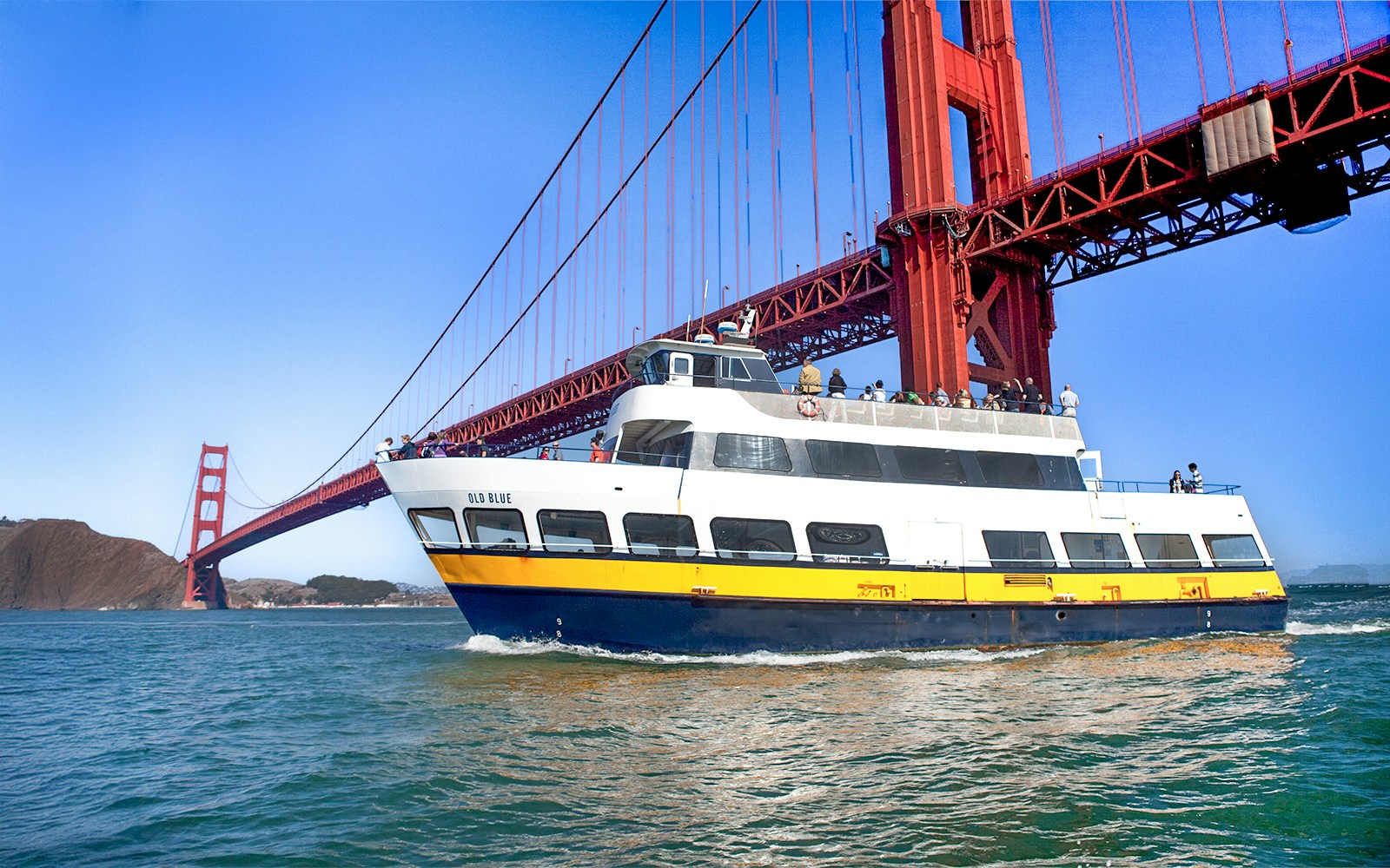 Ferry passing under the Golden Gate Bridge in San Francisco.