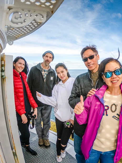 Family on Bruny Island lighthouse balcony with ocean view.