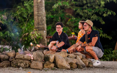 Tourists roasting marshmallows at a campfire in Dream Forest Langkawi.